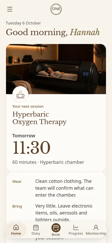The member hub home on a phone, with sample data: “Good morning, Hannah” and her next session, Hyperbaric Oxygen Therapy tomorrow at 11:30 in the hyperbaric chamber, with what to wear and bring, above the Home, Diary, Book, Progress and Membership tabs.